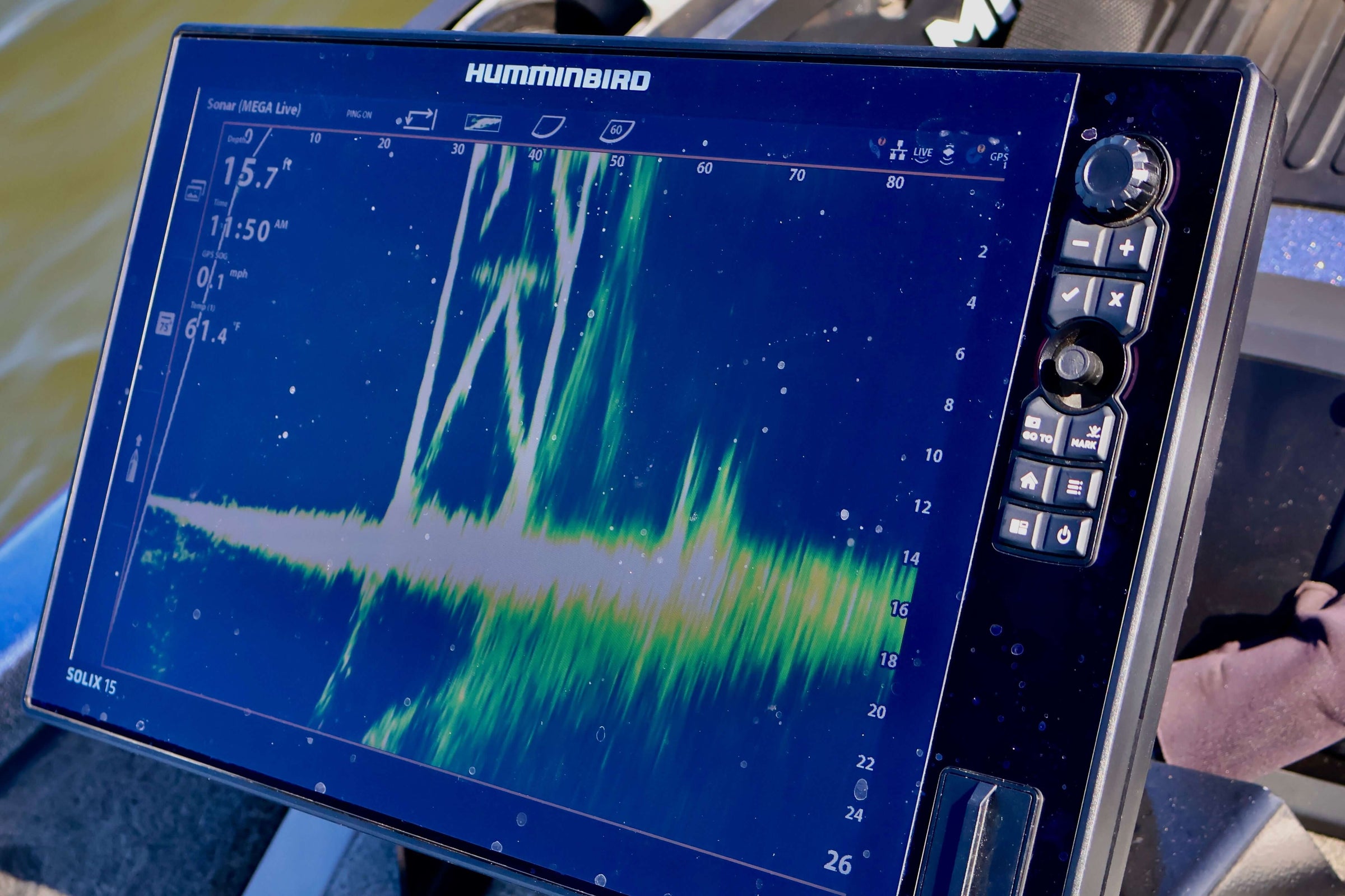 Fish finder display showing sonar data in a boat on the water.
