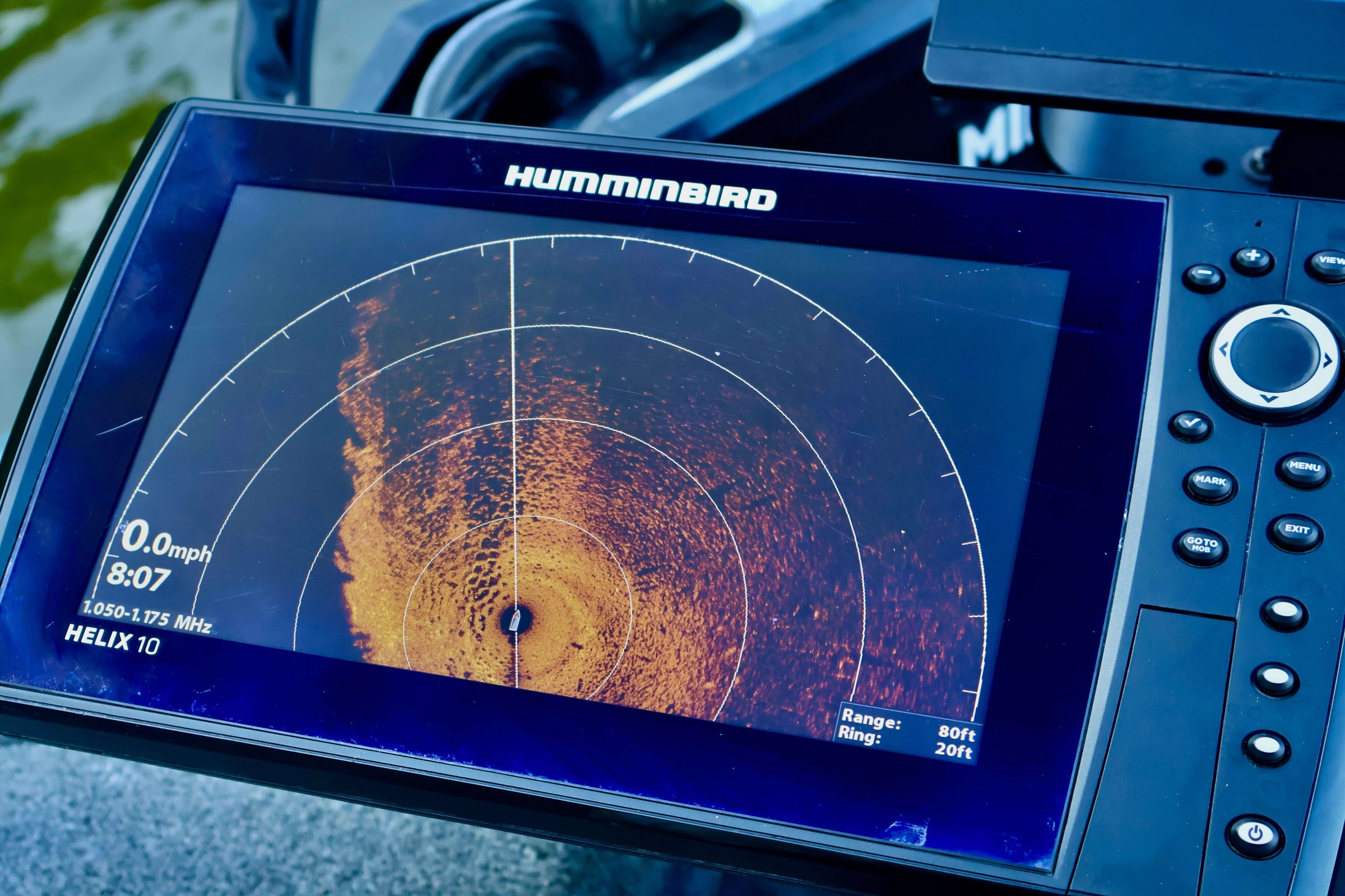 Fish finder sonar display showing underwater scan on a Humminbird Helix 10 device during a boat trip on the lake.