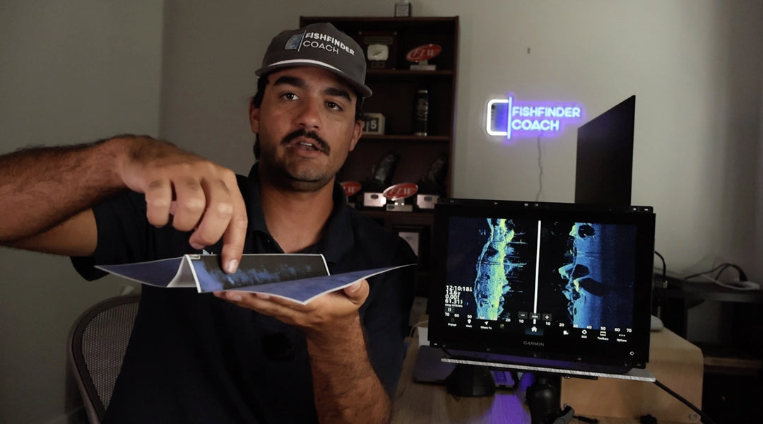 Man holding a tablet displaying a side imaging image with a screen in the background showing 'Fishfinder Coach'.